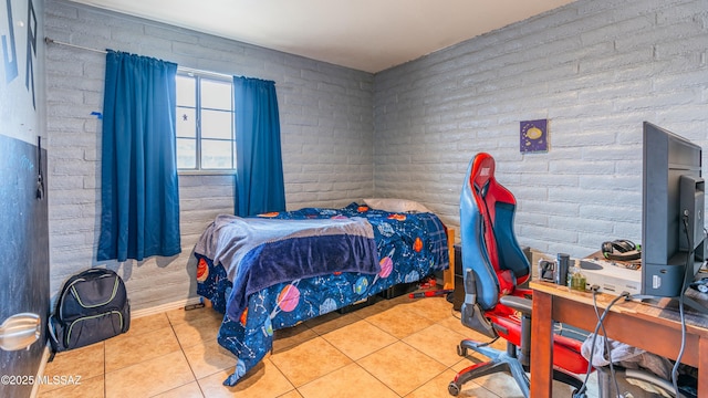 tiled bedroom featuring brick wall