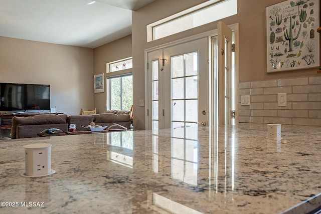 kitchen featuring decorative backsplash and light stone countertops