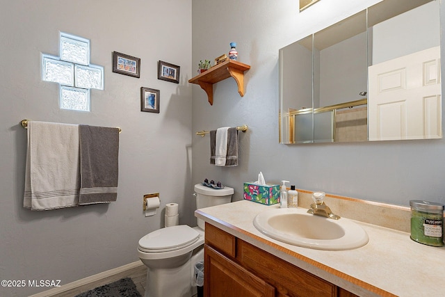 bathroom featuring a shower with door, vanity, and toilet