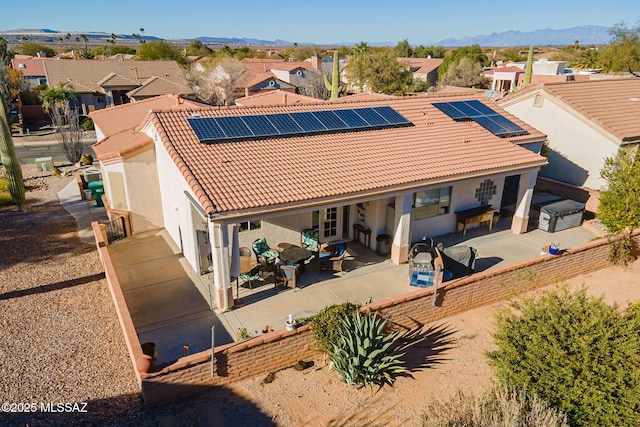 back of house featuring a mountain view, a patio, and solar panels