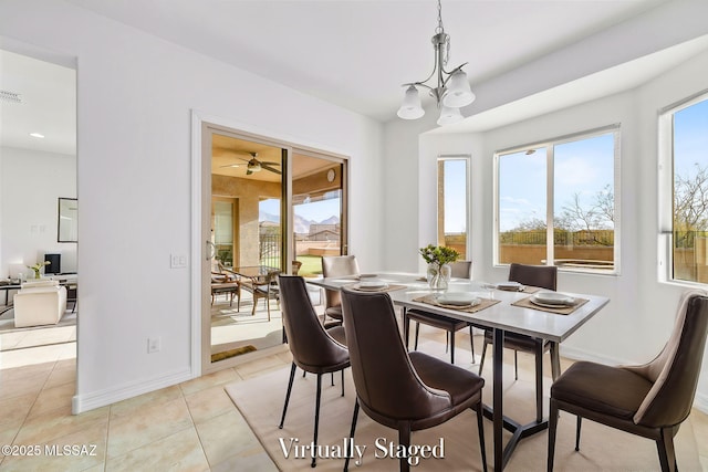 tiled dining space featuring ceiling fan with notable chandelier and a healthy amount of sunlight