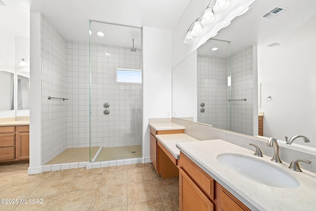 bathroom featuring tile patterned floors, vanity, and tiled shower