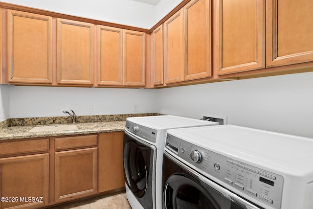 washroom featuring cabinets, washing machine and dryer, light tile patterned flooring, and sink