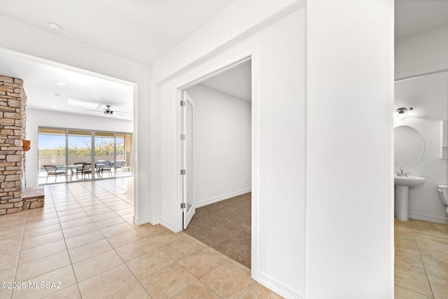 hallway featuring sink and light colored carpet