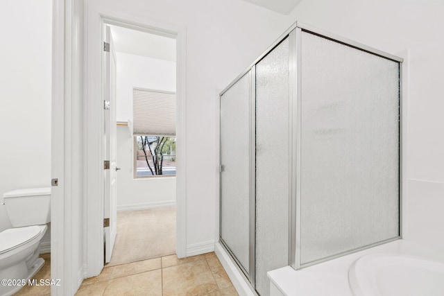 bathroom featuring tile patterned flooring, separate shower and tub, and toilet