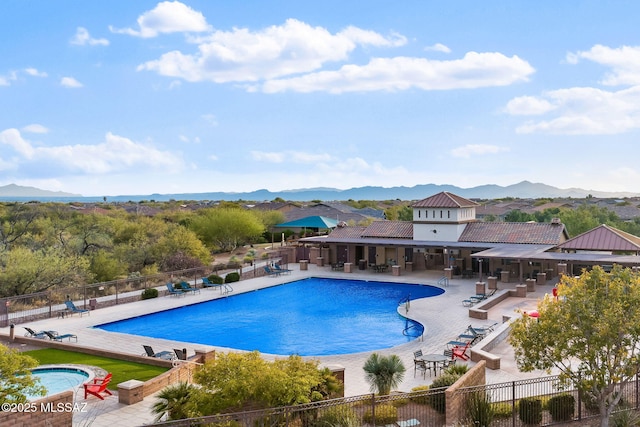 view of pool with a jacuzzi, a mountain view, and a patio area