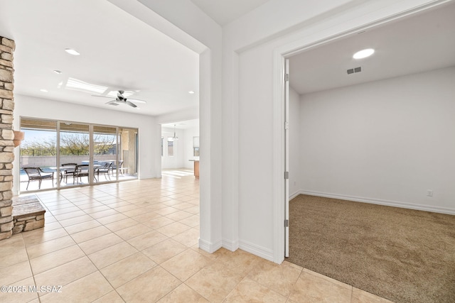 hallway featuring light colored carpet