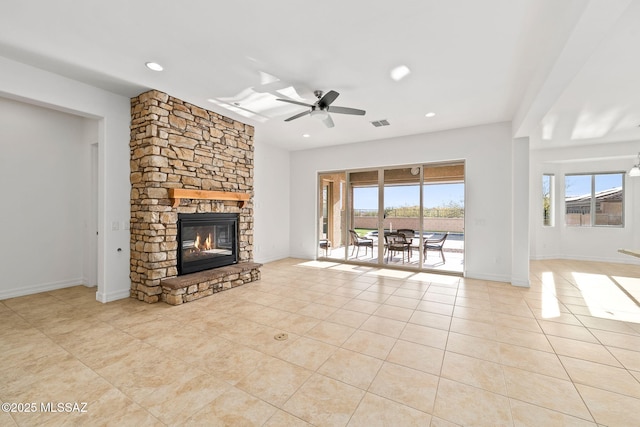 unfurnished living room with ceiling fan, a fireplace, and light tile patterned flooring