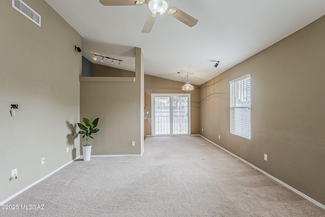 spare room with vaulted ceiling, carpet, visible vents, and baseboards