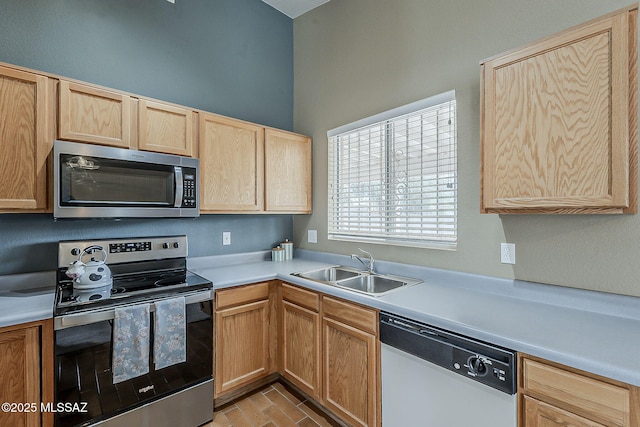 kitchen featuring light brown cabinets, stainless steel appliances, a sink, and light countertops