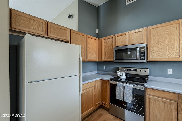 kitchen featuring visible vents, appliances with stainless steel finishes, light countertops, and light brown cabinetry