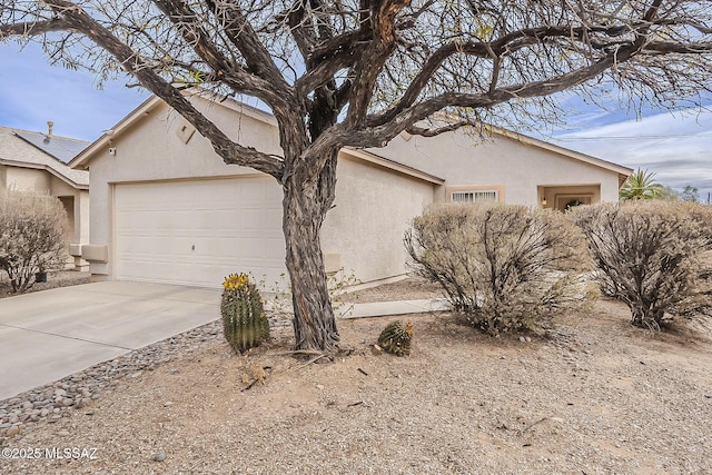 view of side of property with a garage, concrete driveway, and stucco siding