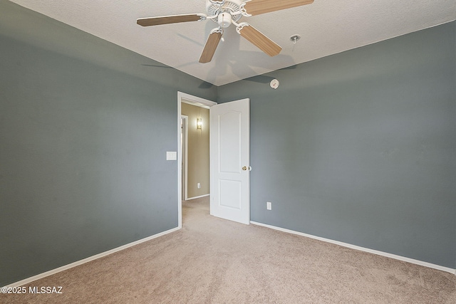 carpeted spare room with ceiling fan, a textured ceiling, and baseboards