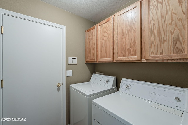 clothes washing area with cabinet space, independent washer and dryer, and a textured ceiling