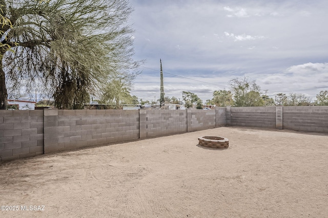 view of yard featuring a fire pit and a fenced backyard