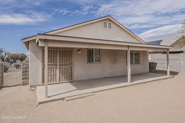 back of house with a patio area, fence, and stucco siding