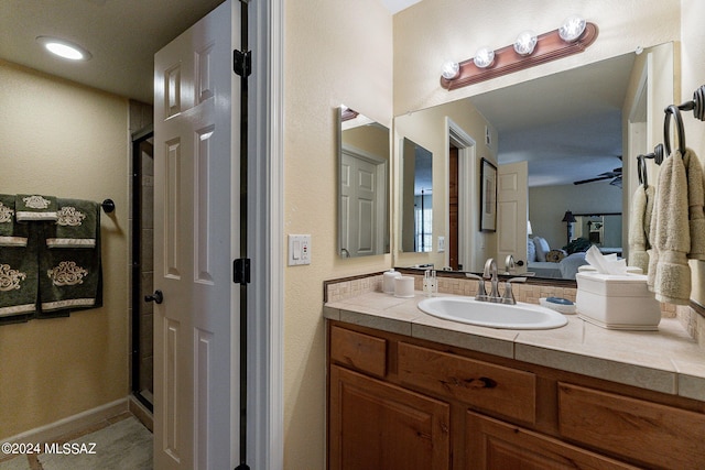 bathroom featuring walk in shower, vanity, tile patterned floors, and ceiling fan