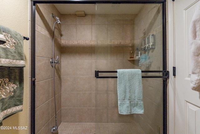 bathroom with a shower with door