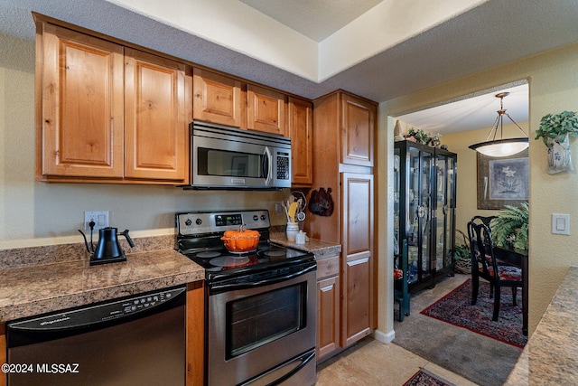 kitchen featuring light tile patterned floors, hanging light fixtures, and appliances with stainless steel finishes