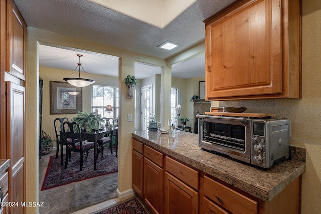 kitchen with decorative light fixtures and a textured ceiling