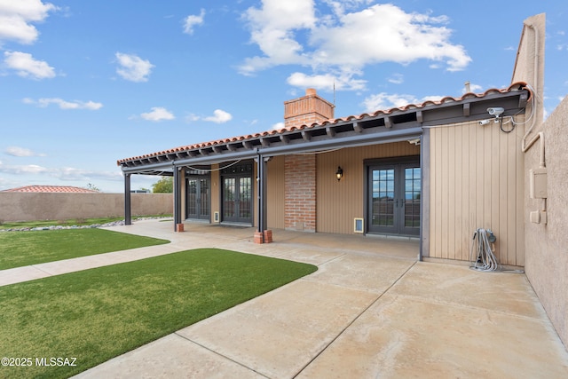 back of property featuring french doors, a patio, and a lawn