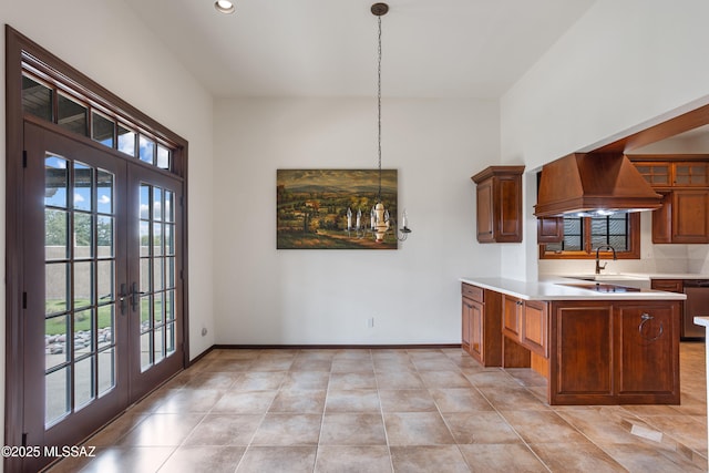 kitchen with kitchen peninsula, french doors, premium range hood, and pendant lighting