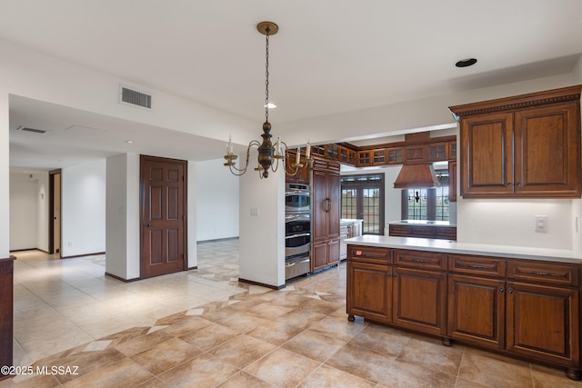 kitchen with pendant lighting, a notable chandelier, double oven, and french doors