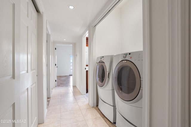 clothes washing area featuring light tile patterned floors and washer and clothes dryer