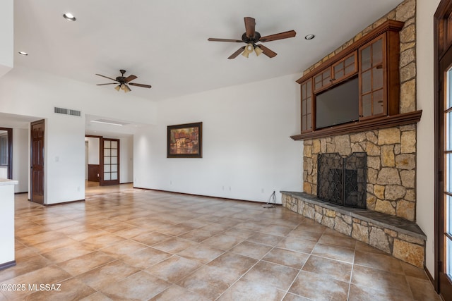 unfurnished living room with a fireplace and ceiling fan