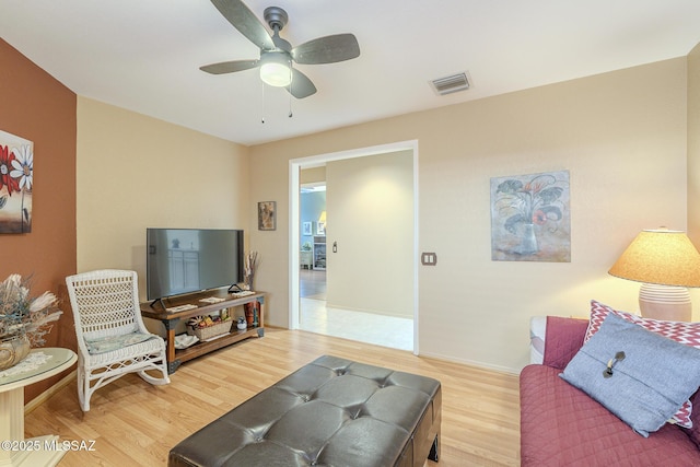 living room featuring ceiling fan and hardwood / wood-style floors