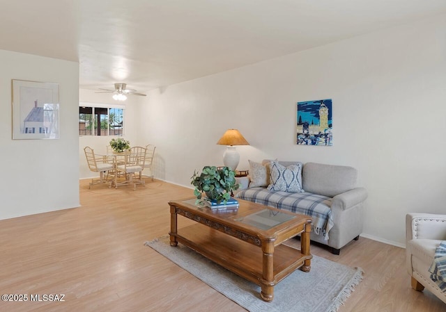 living room featuring ceiling fan and light hardwood / wood-style flooring