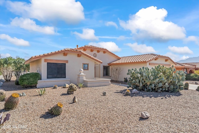 view of front of house featuring a tile roof and stucco siding