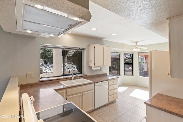 kitchen featuring recessed lighting, light tile patterned flooring, white dishwasher, a textured ceiling, and a sink