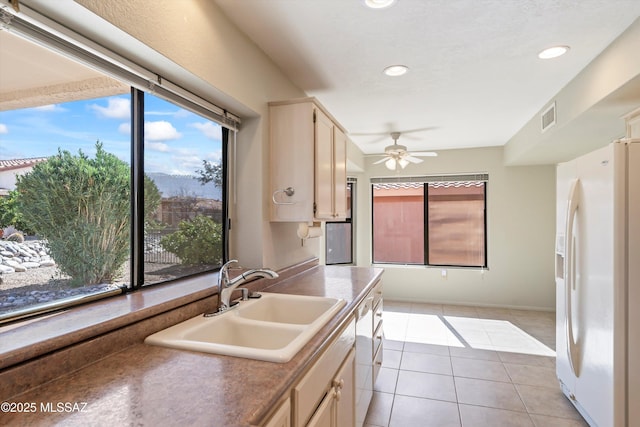 kitchen featuring white appliances, light tile patterned floors, visible vents, a sink, and recessed lighting