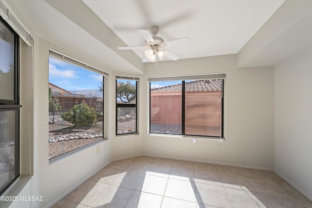 unfurnished room with light tile patterned floors, ceiling fan, and baseboards