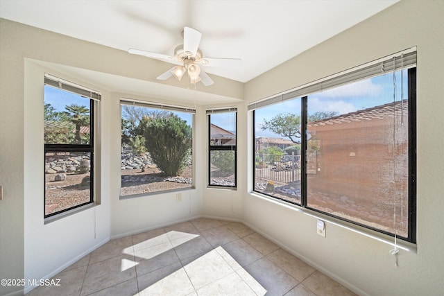 unfurnished sunroom featuring ceiling fan