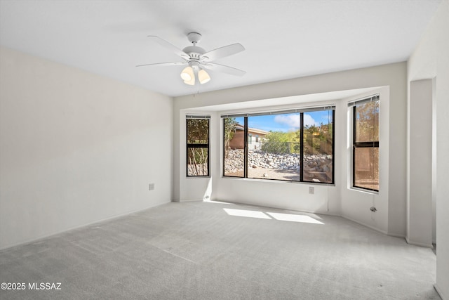 carpeted spare room with ceiling fan