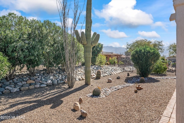 view of yard with fence and a mountain view