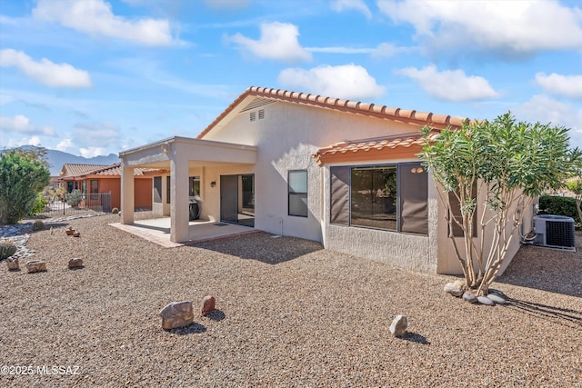 back of house featuring cooling unit, fence, a tile roof, stucco siding, and a patio area