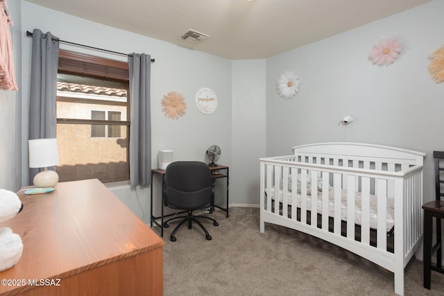 carpeted bedroom featuring a nursery area