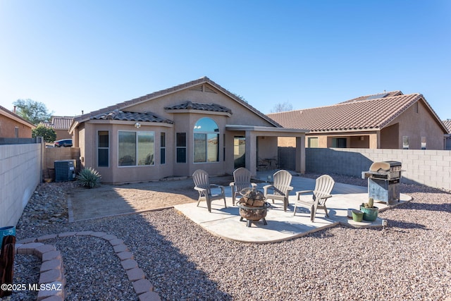 back of property featuring a fire pit, a patio area, and central AC