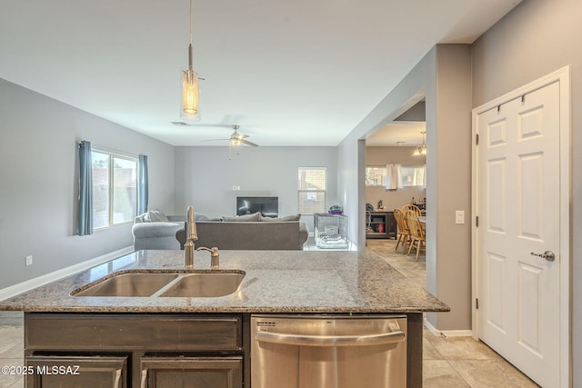 kitchen featuring light stone counters, stainless steel dishwasher, ceiling fan, sink, and decorative light fixtures