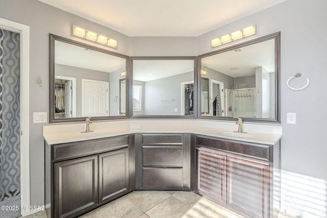 bathroom with a shower, tile patterned flooring, and vanity