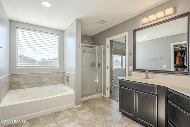 bathroom featuring tile patterned flooring, vanity, and plus walk in shower