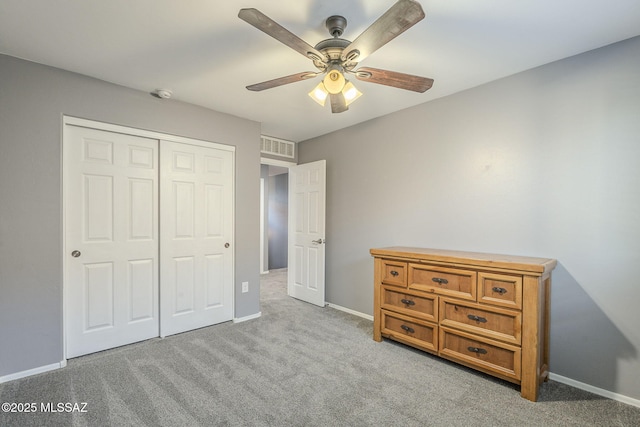 unfurnished bedroom with ceiling fan, light carpet, and a closet