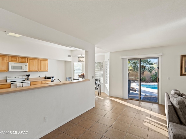 kitchen with white appliances, light brown cabinets, an inviting chandelier, and light tile patterned flooring