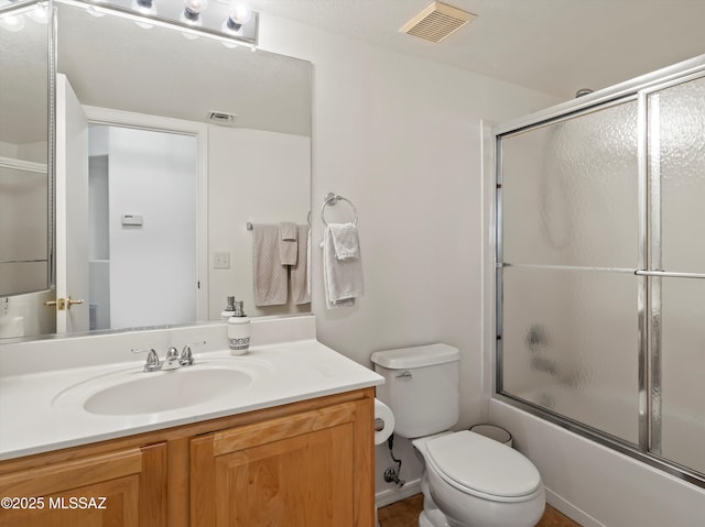 full bathroom featuring enclosed tub / shower combo, toilet, and vanity