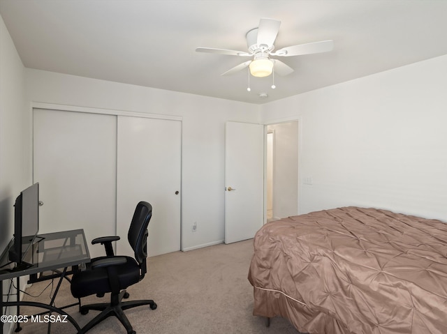 bedroom featuring ceiling fan, light colored carpet, and a closet