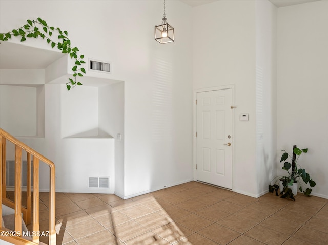 tiled foyer entrance with a towering ceiling