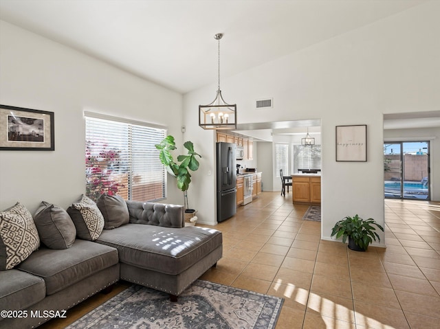 tiled living room featuring a chandelier and lofted ceiling